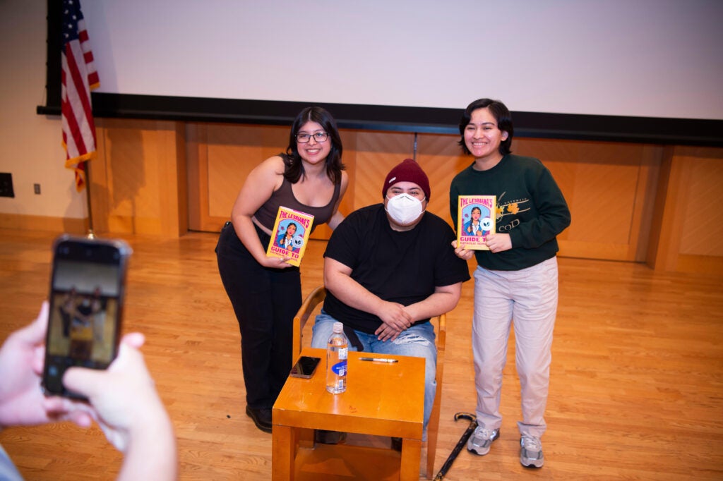 Two students pose to take a picture with author Sonora Reyes at the Intersectionality event in 2023